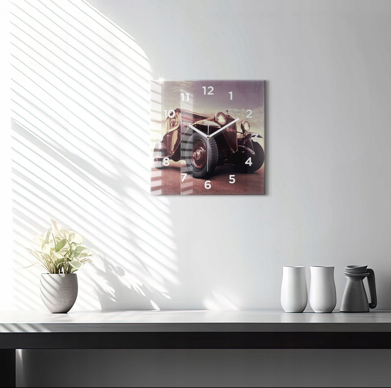 Veggklokke i glass med retro bilmotiv på lys vegg over bord