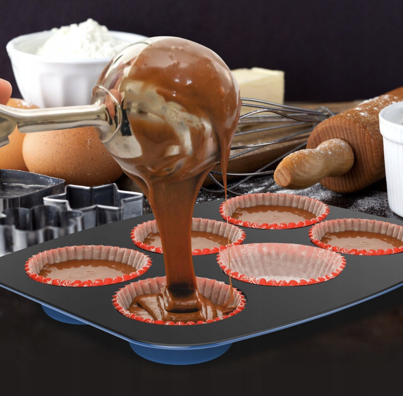 Muffinsbrett med sjokoladerøre og bakeformer i bruk på kjøkkenbenk