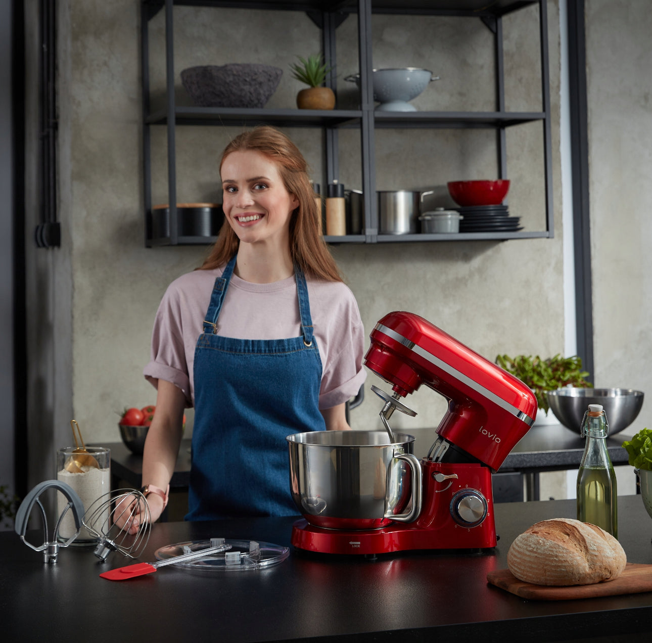 Kvinne i kjøkkenmiljø med rød kjøkkenmaskin og bakeutstyr på benken