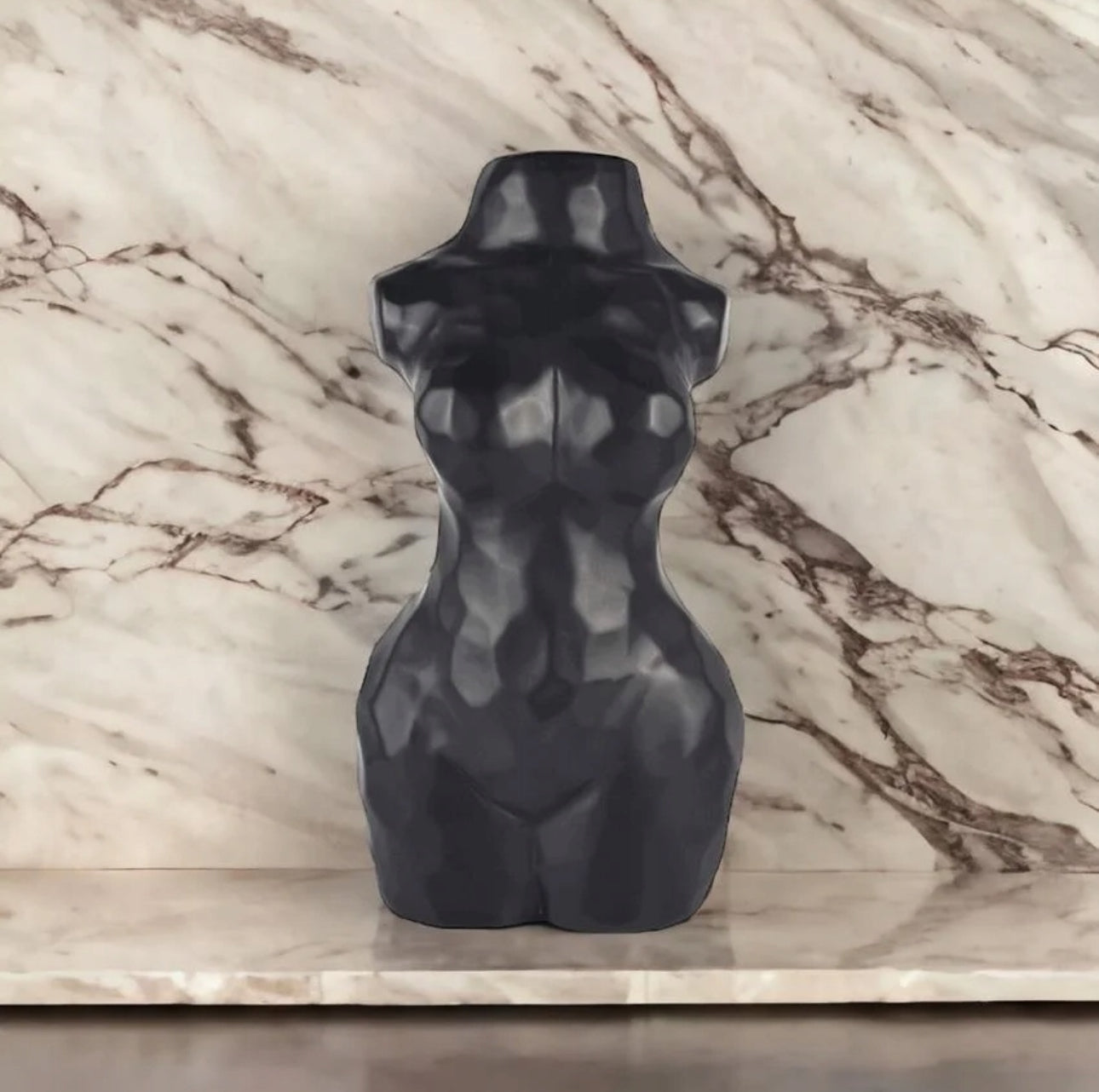 Nærbilde av sort vase med kunstnerisk kroppsfasong