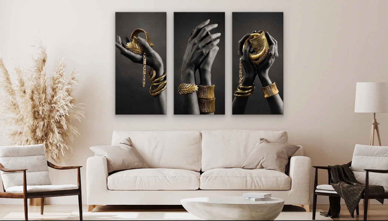 Moderne stue med tre gull og svart lerretsbilder over lys sofa