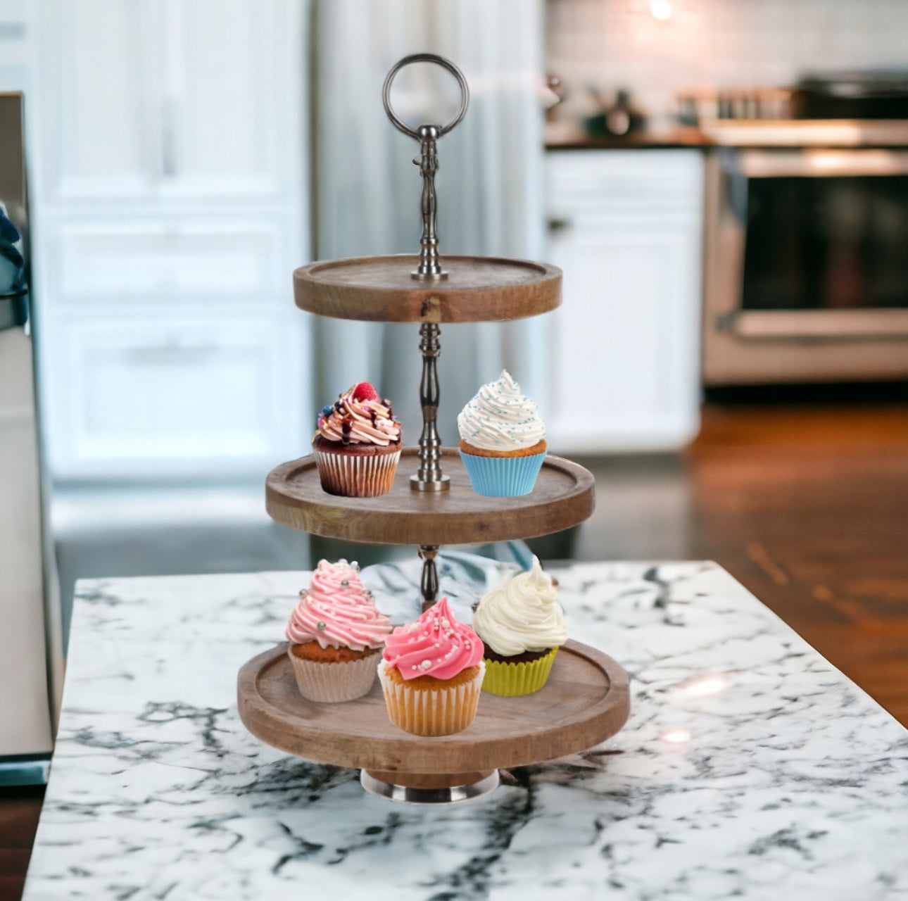 Treetasjes serveringsfat i naturlig tre med metallhåndtak, plassert på kjøkkenbenk med cupcakes i ulike farger