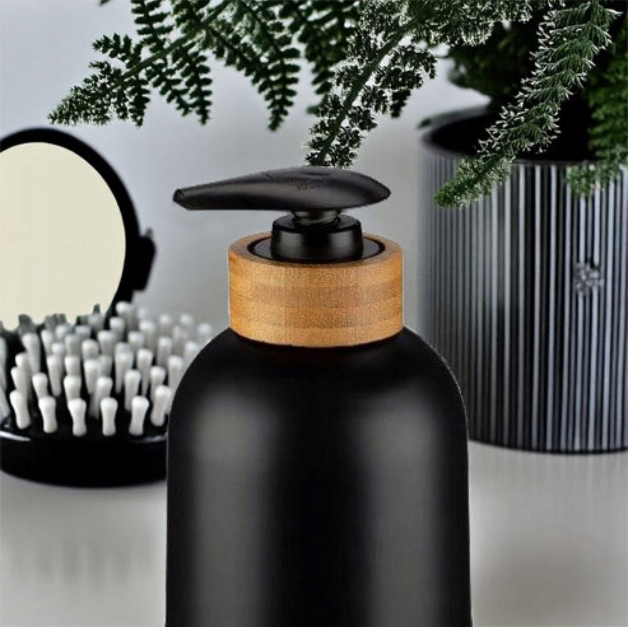 Elegant svart såpedispenser med bambusdetaljer – ideell for moderne bad og kjøkken. Minimalistisk design og miljøvennlige materialer for stil og funksjonalitet.
