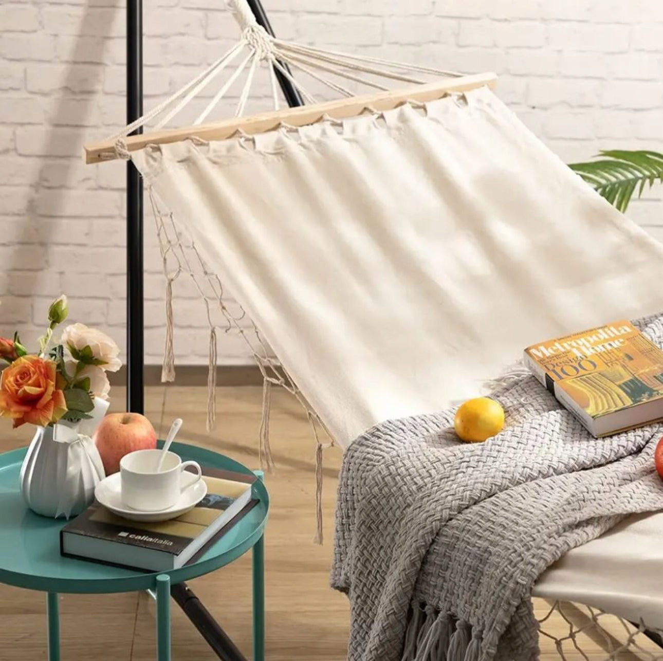 Elegant hengekøye i boho-stil plassert innendørs med bok, pledd og frukt