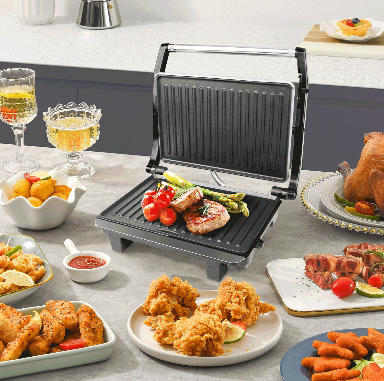 Elektrisk bordgrill i bruk med grillet kjøtt, asparges og tomater i kjøkkenmiljø