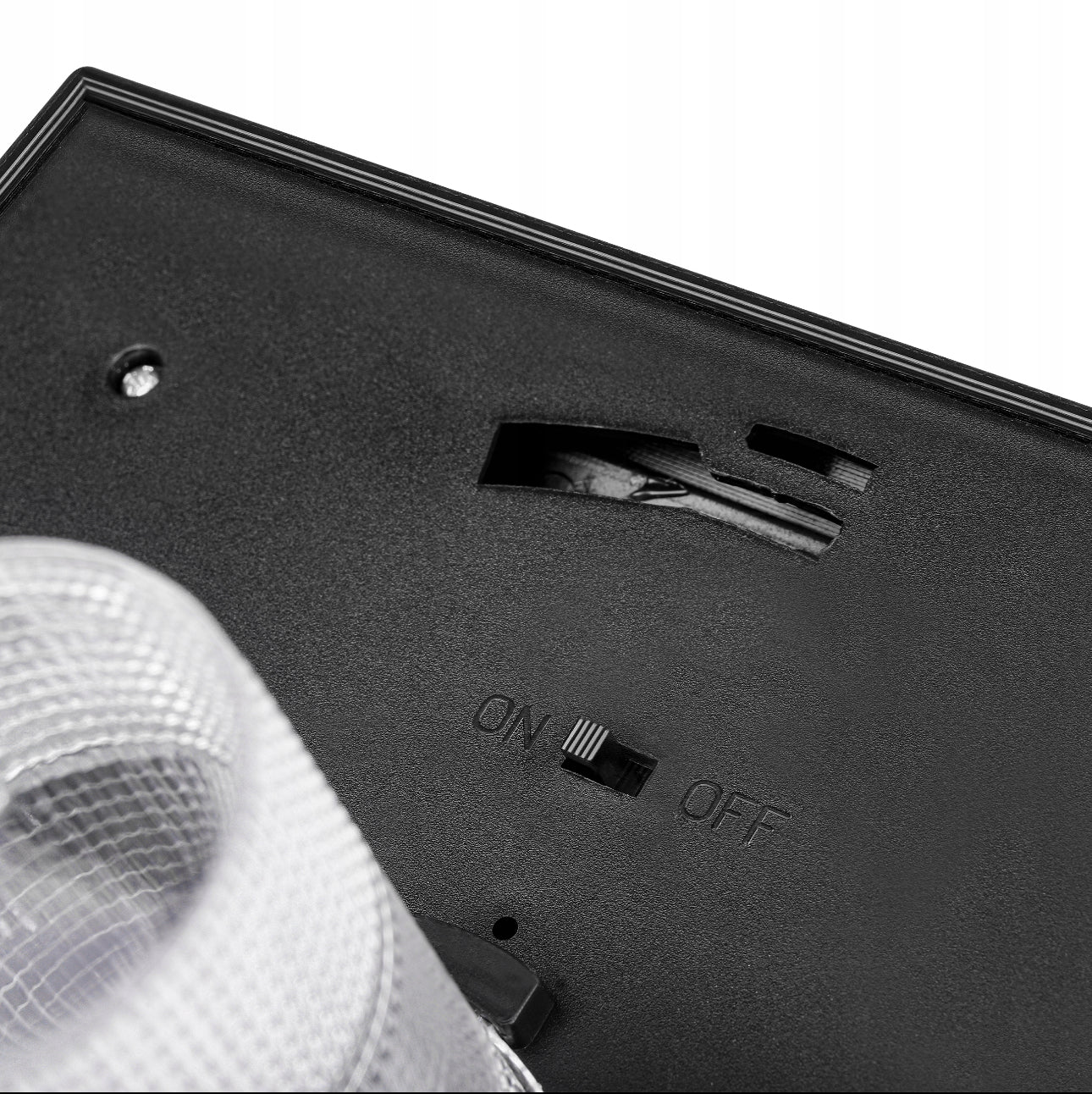 Underside av solcellelampe med av/på-bryter og batterirom.