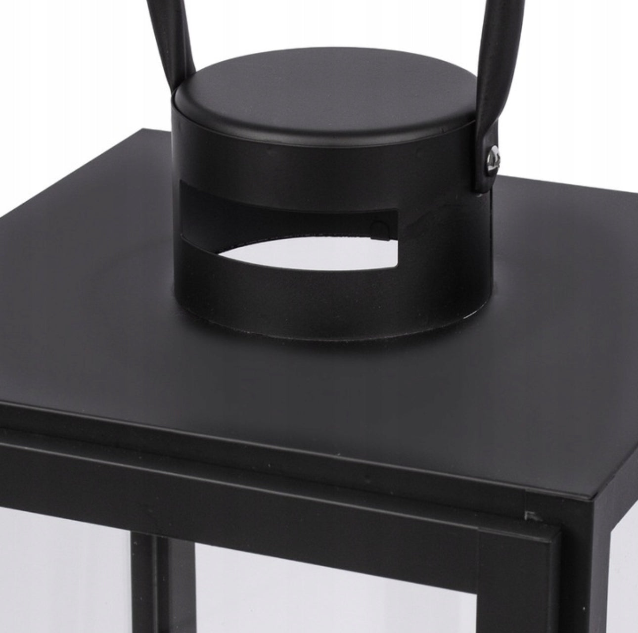 Toppdel med bærehåndtak på svart metallisk lyslykt, detaljvisning