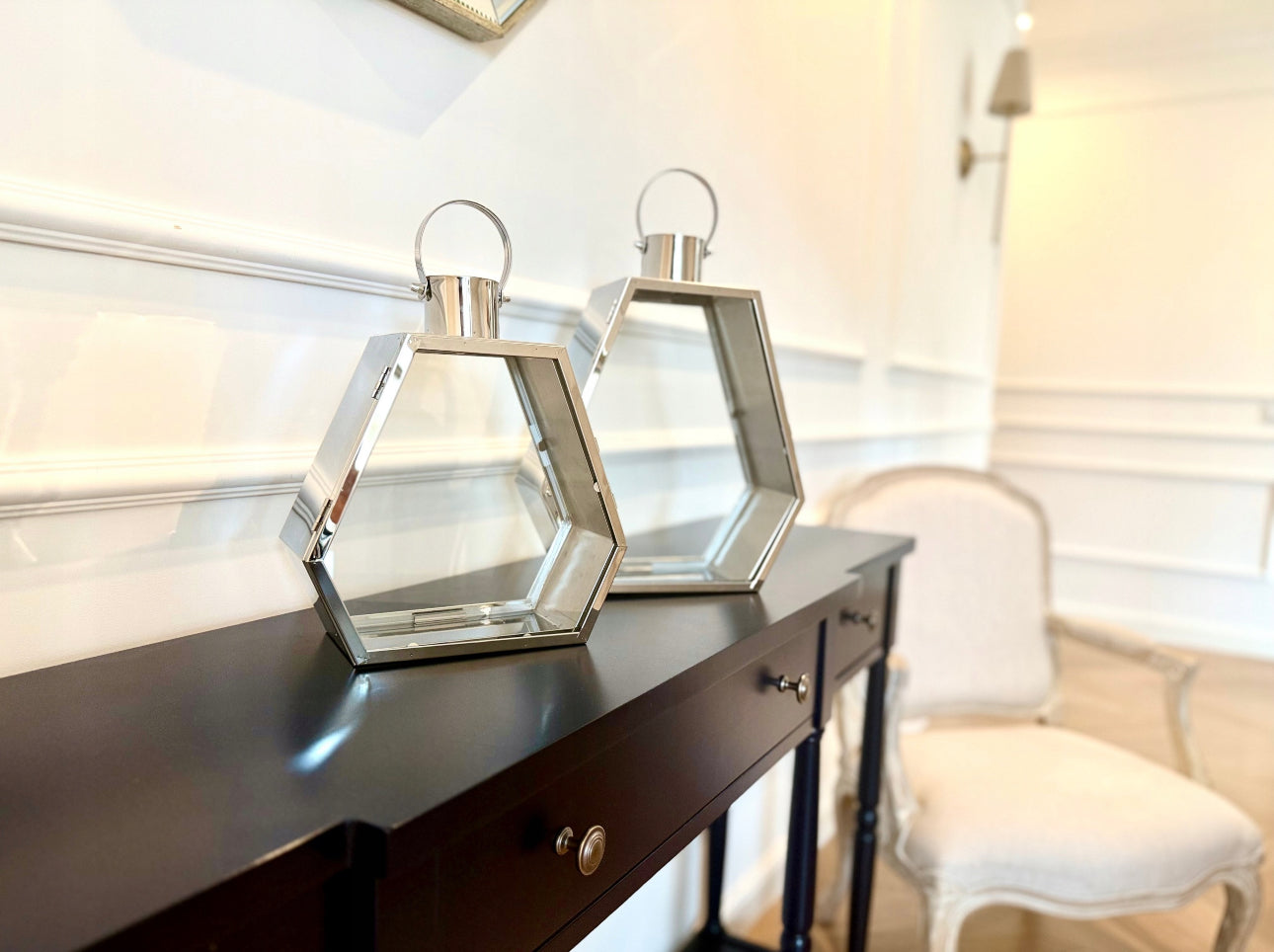 Glamour lykter i sølv på svart konsollbord i klassisk interiør