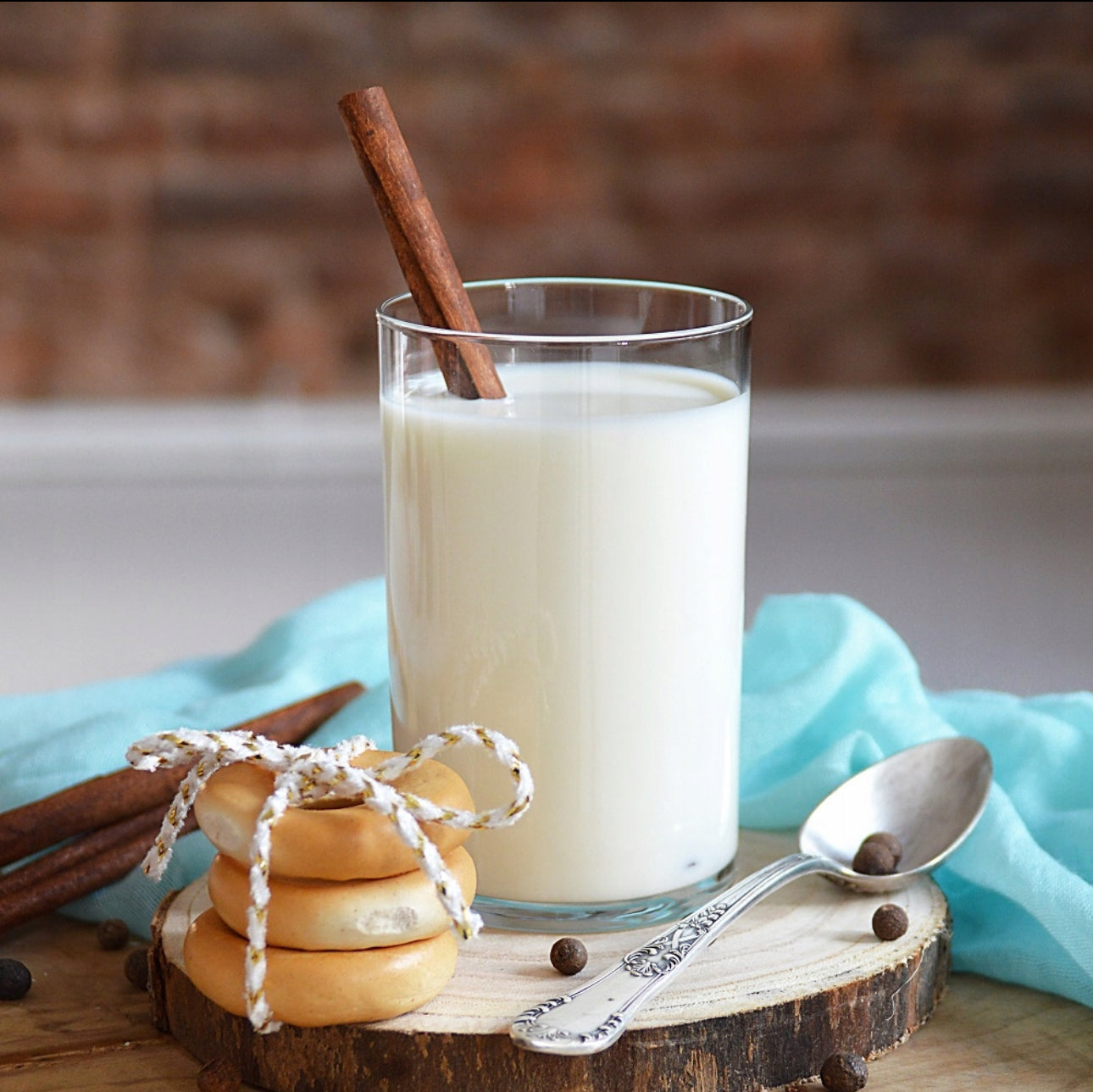 Glass fylt med melk og kanelstang, servert med småkaker