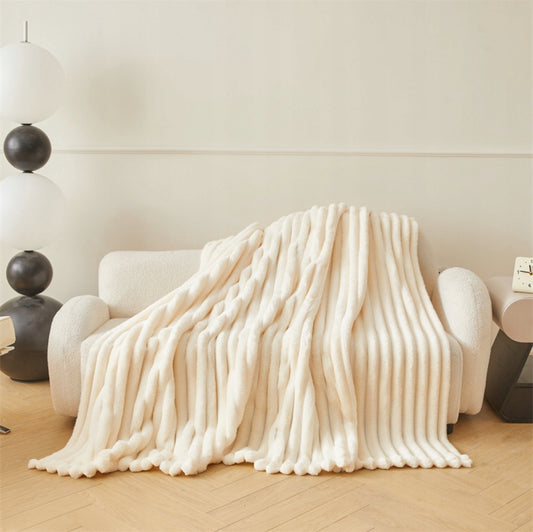 Kremfarget 3D-pledd drapert over lys sofa i moderne stue