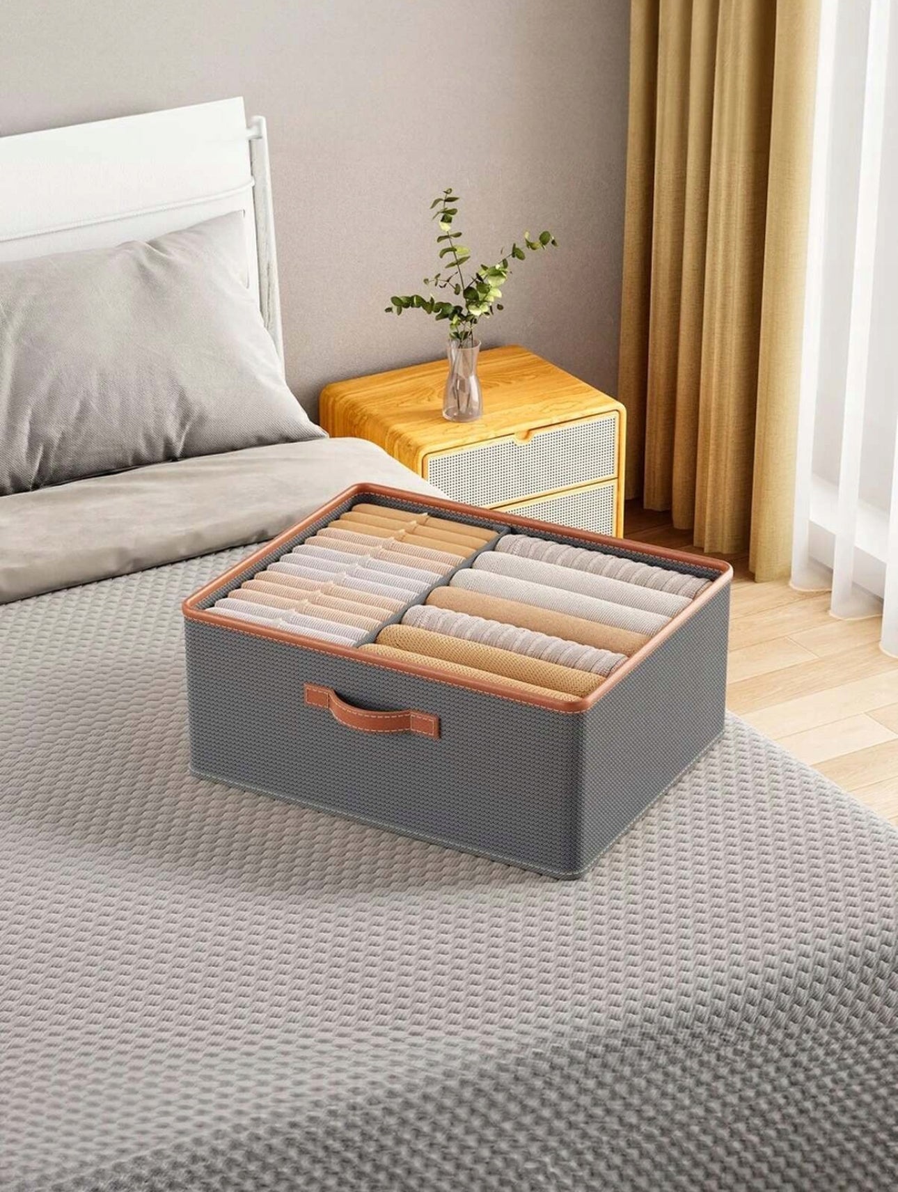 Grå oppbevaringsboks i tekstil med brunt håndtak, størrelse 40x50x20 cm, slitesterk og solid materiale for klær og tilbehør.