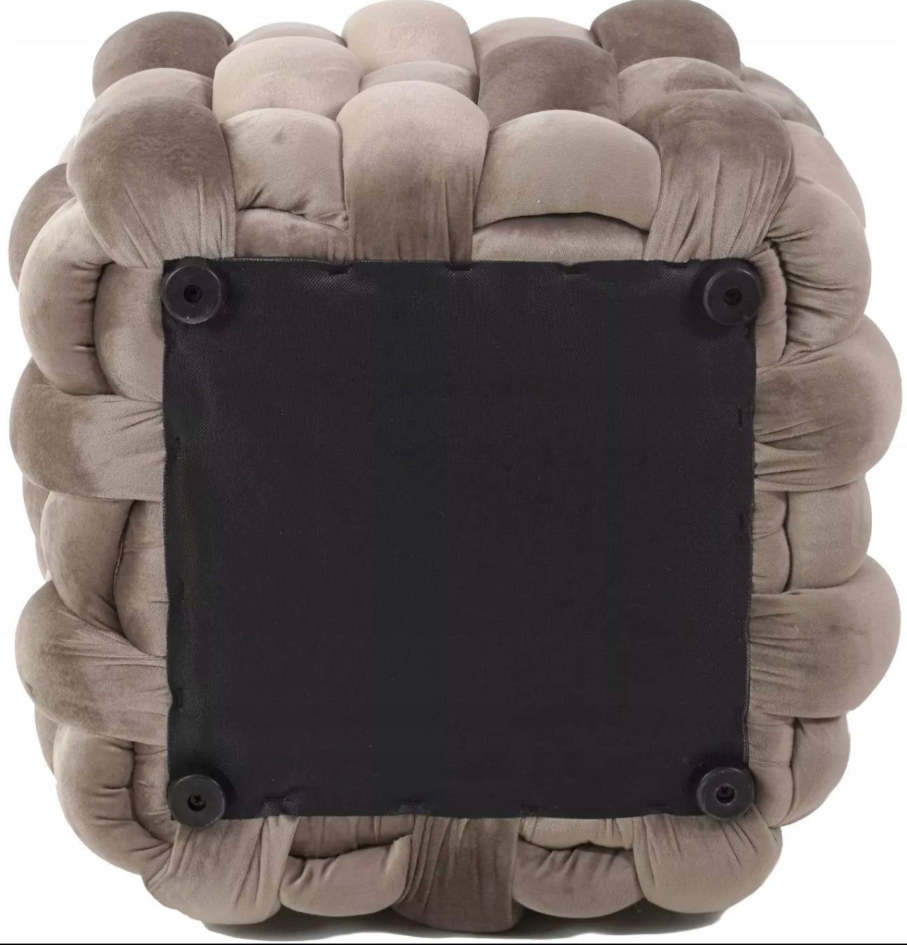 Underside av beige puff med sorte knotter og mørk tekstilbunn