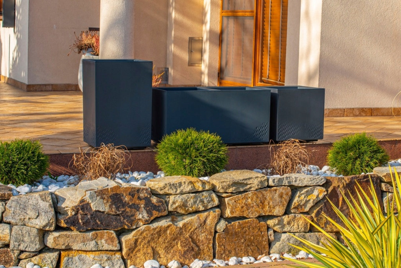 Moderne antrasittgrå blomsterkasse 40x40 cm – laget av værbestandig, resirkulert plast med betonglook. Frostsikker, UV-bestandig og utstyrt med dreneringshull og hjul for enkel flytting. Perfekt til hage, terrasse og balkong.