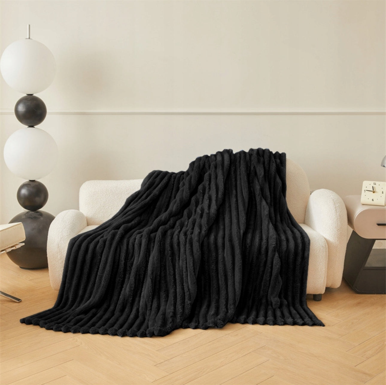 Sort mikrofiber pledd med tykk struktur over sofa i stue