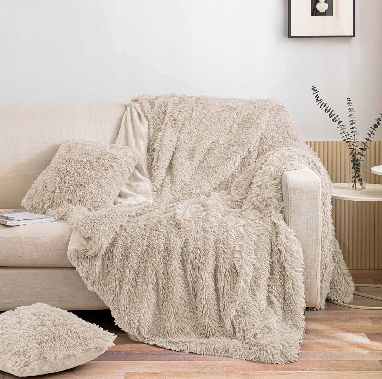 Lys beige fuskepelspledd og matchende pute på lys sofa i stue