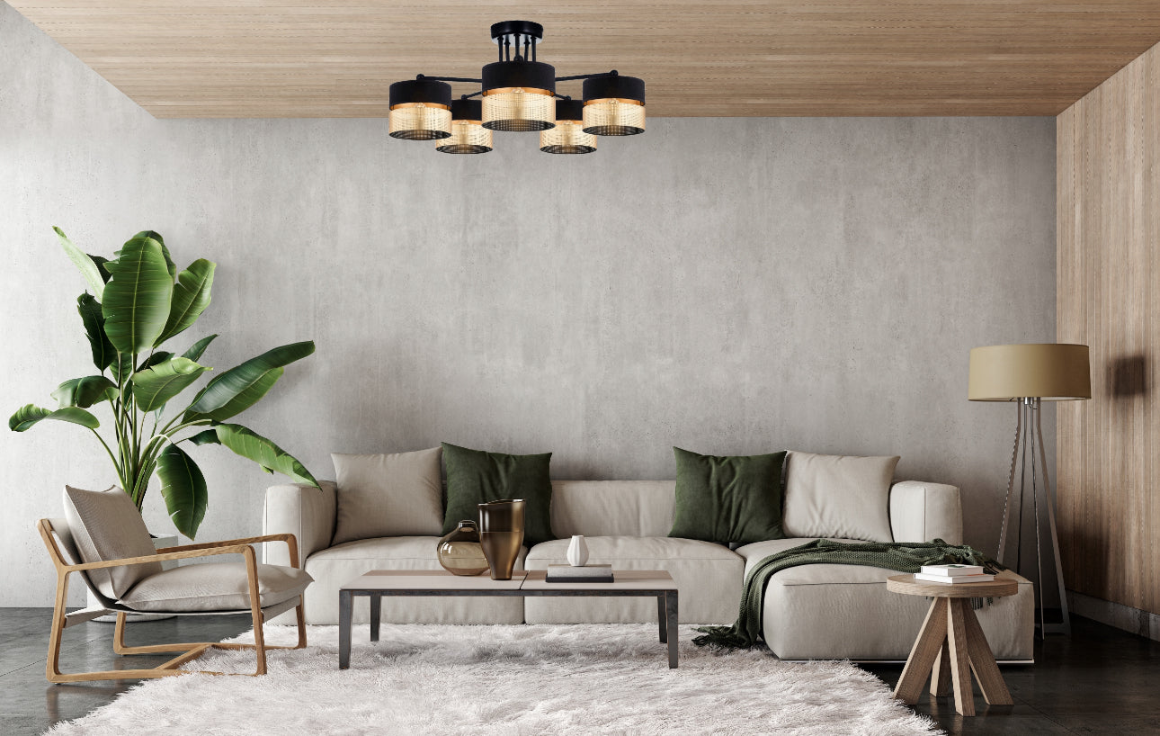 Elegant stue med svart og gull taklampe over sofa og grønne detaljer