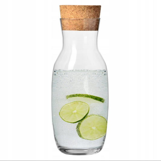 Klar glasskaraffel med korklokk fylt med vann og lime