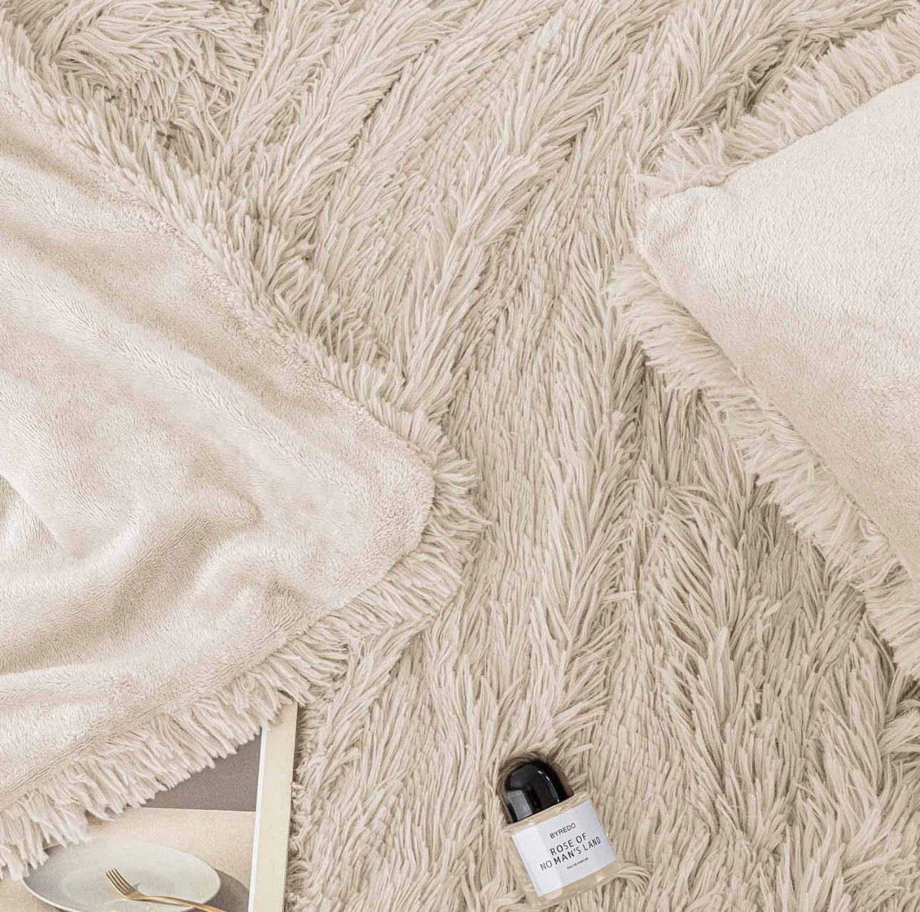 Nærbilde av lys beige pledd med fluffy overflate og glatt innside