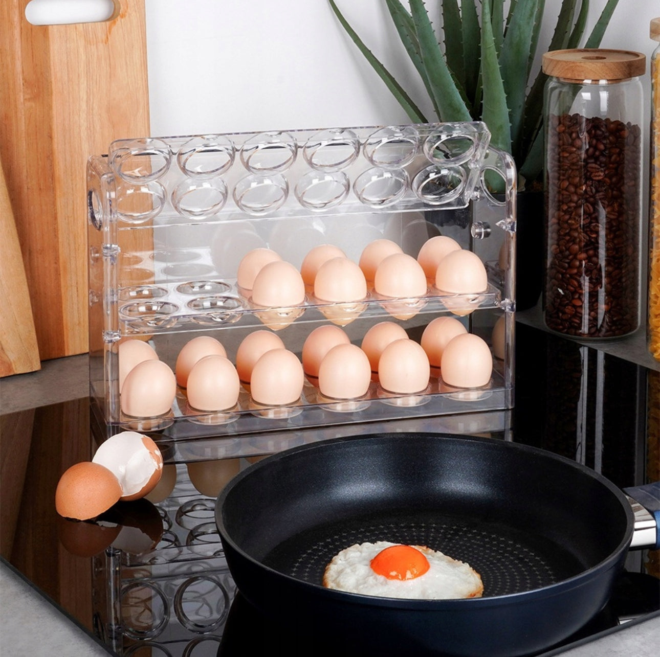 Kjøkkenmiljø med eggstativ fylt med egg og stekepanne med speilegg foran