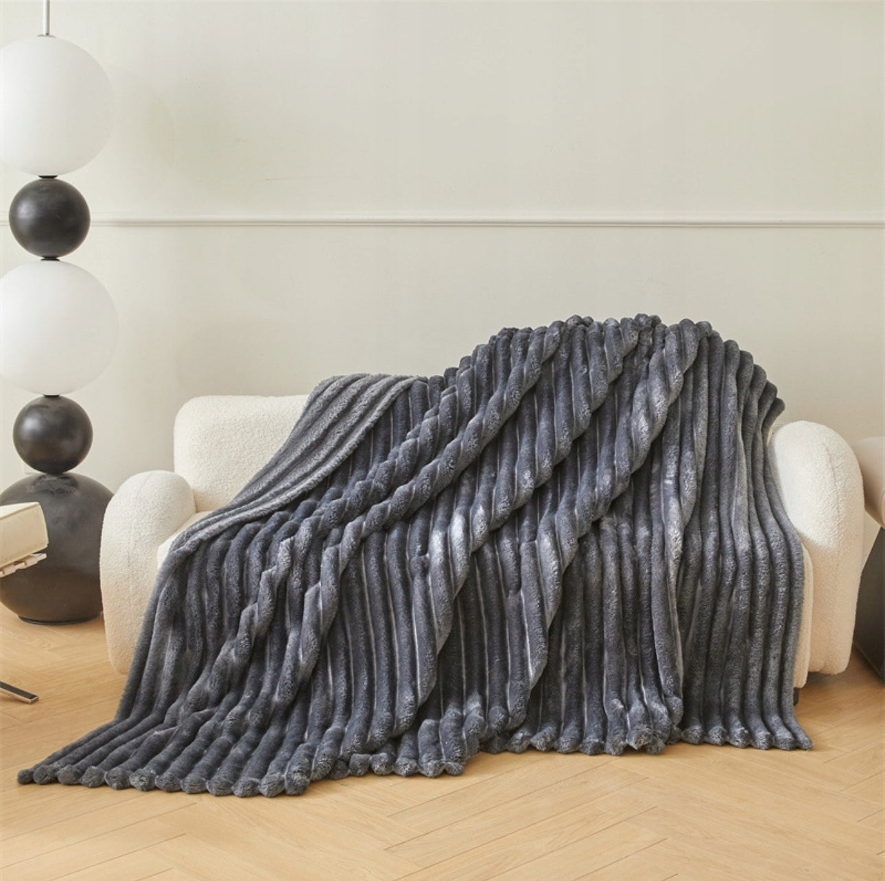 Grått mikrofiber pledd med bred stripeeffekt, elegant drapert i stue