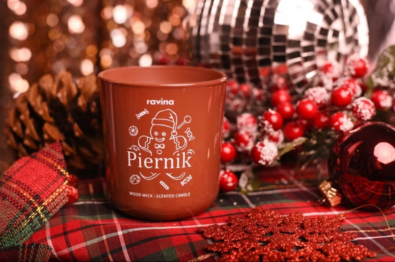 Aromatisk duftlys med treveke og pepperkakedesign foran julekuler og glitterdekorasjoner