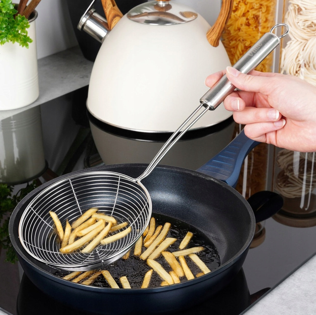 Sleiv i bruk over stekepanne med frityrstekte pommes frites