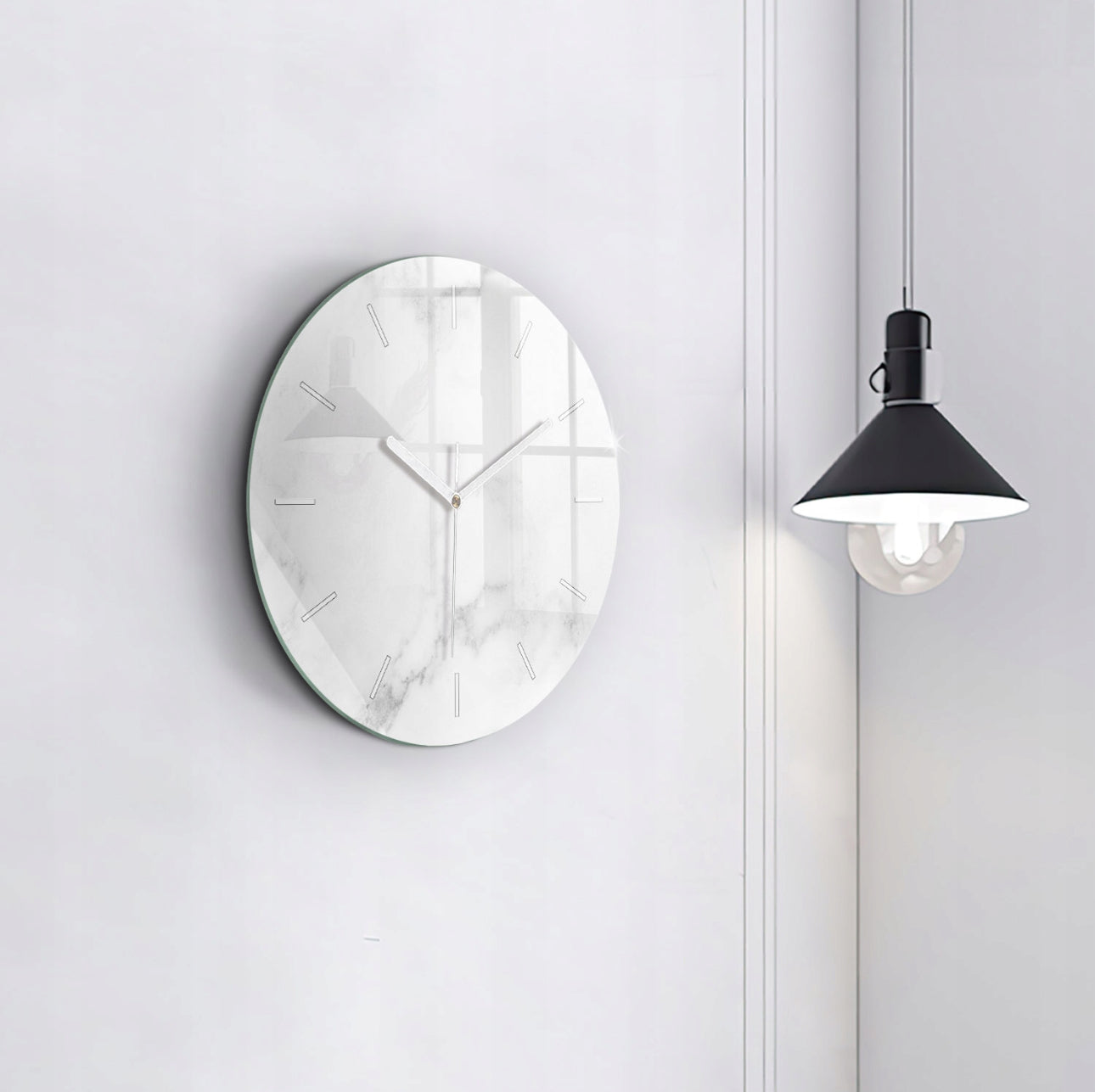 Minimalistisk glassklokke med hvite visere på marmormønstret bakgrunn ved svart taklampe