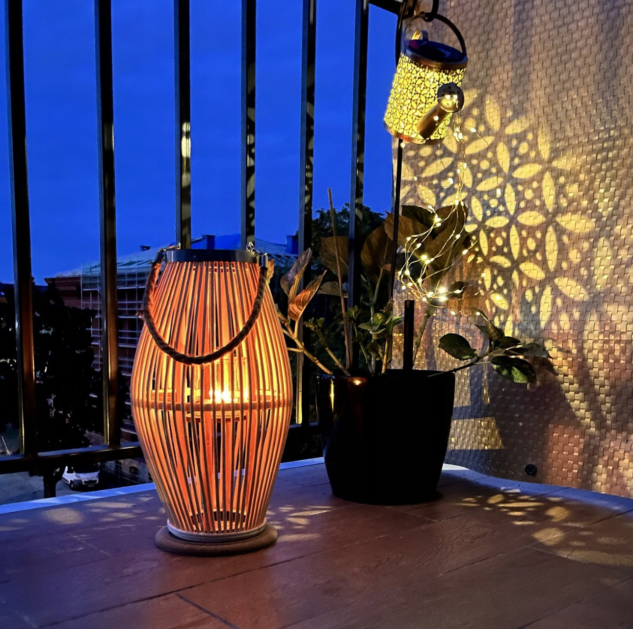 Tent bambuslyslykt på balkong ved solnedgang, omgitt av planter og mønsterskygger