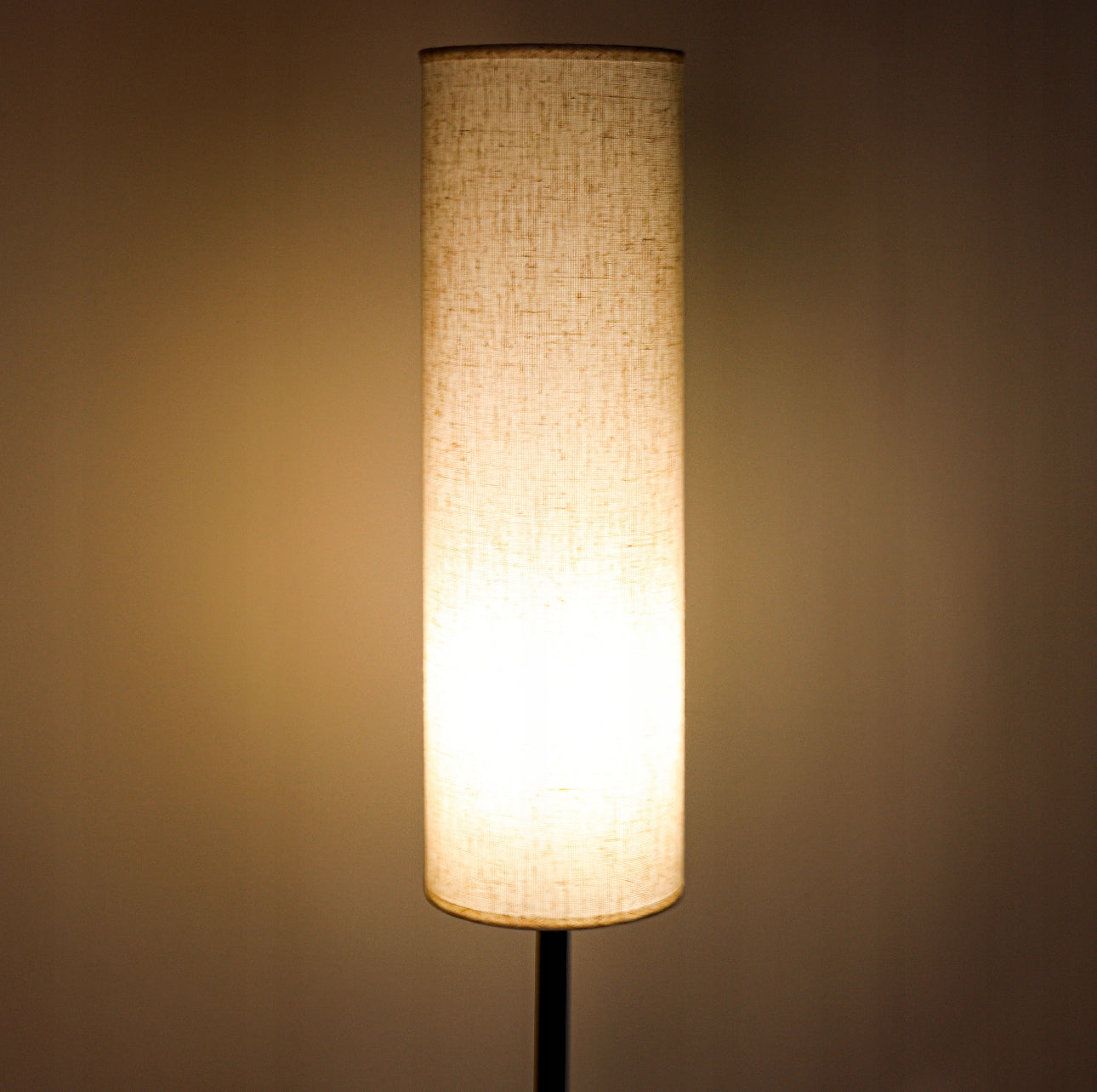 Nærbilde av tent gulvlampe med lys beige tekstilskjerm