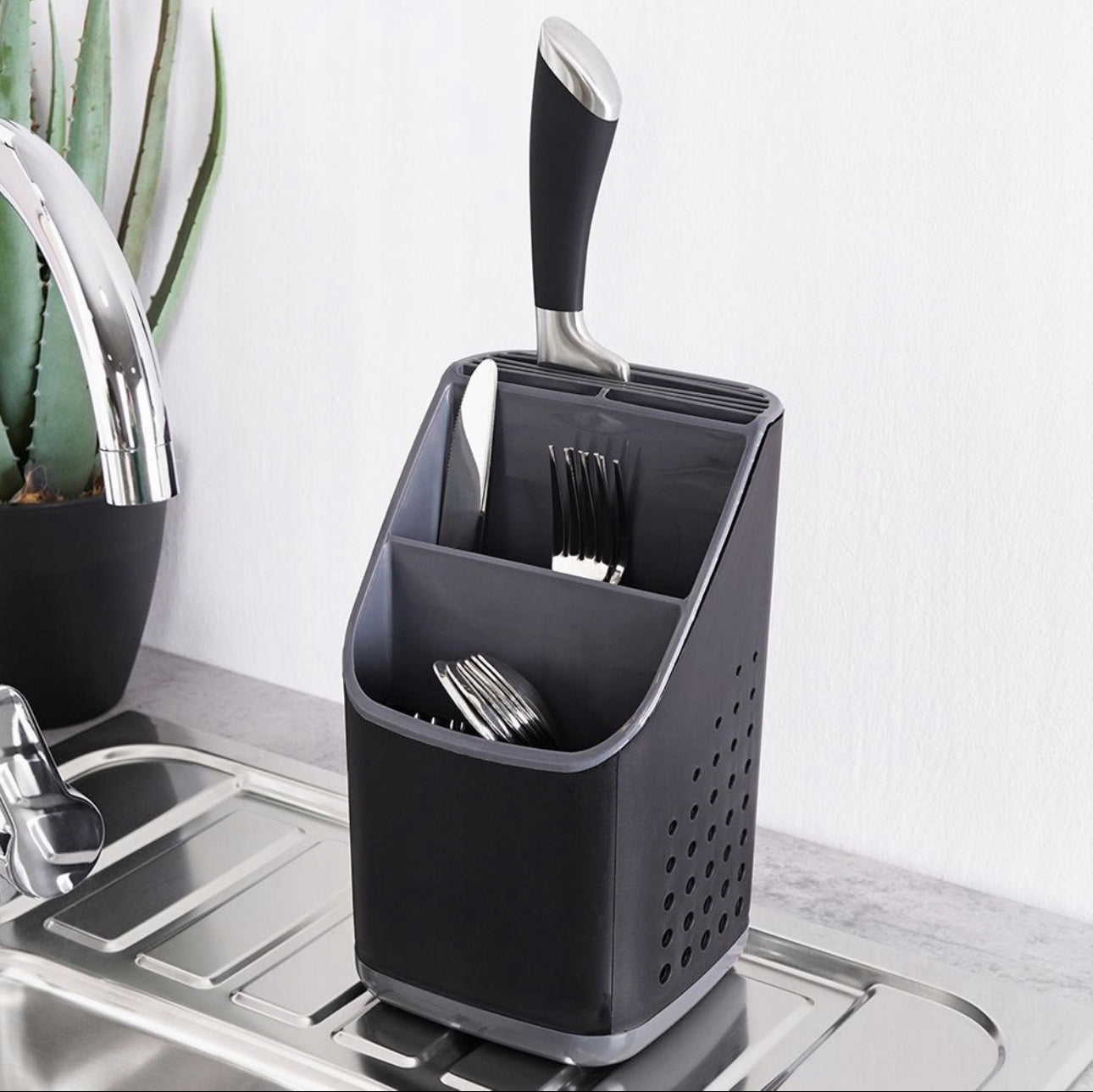 Bestikkholder i plast plassert ved vask med kniver, gafler og skjeer