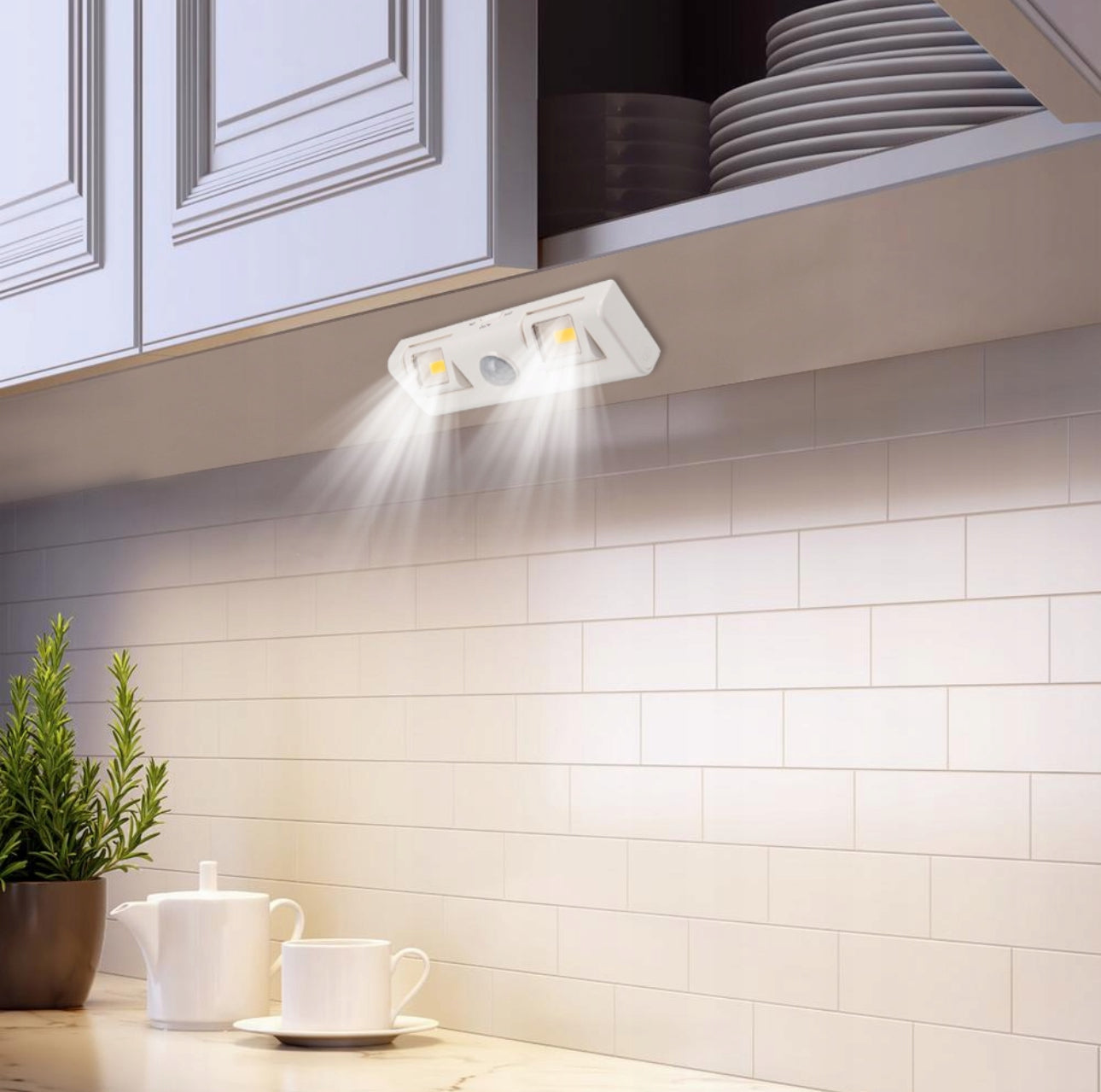 Hvit LED lampe montert under kjøkkenskap som lyser ned på benkeplate
