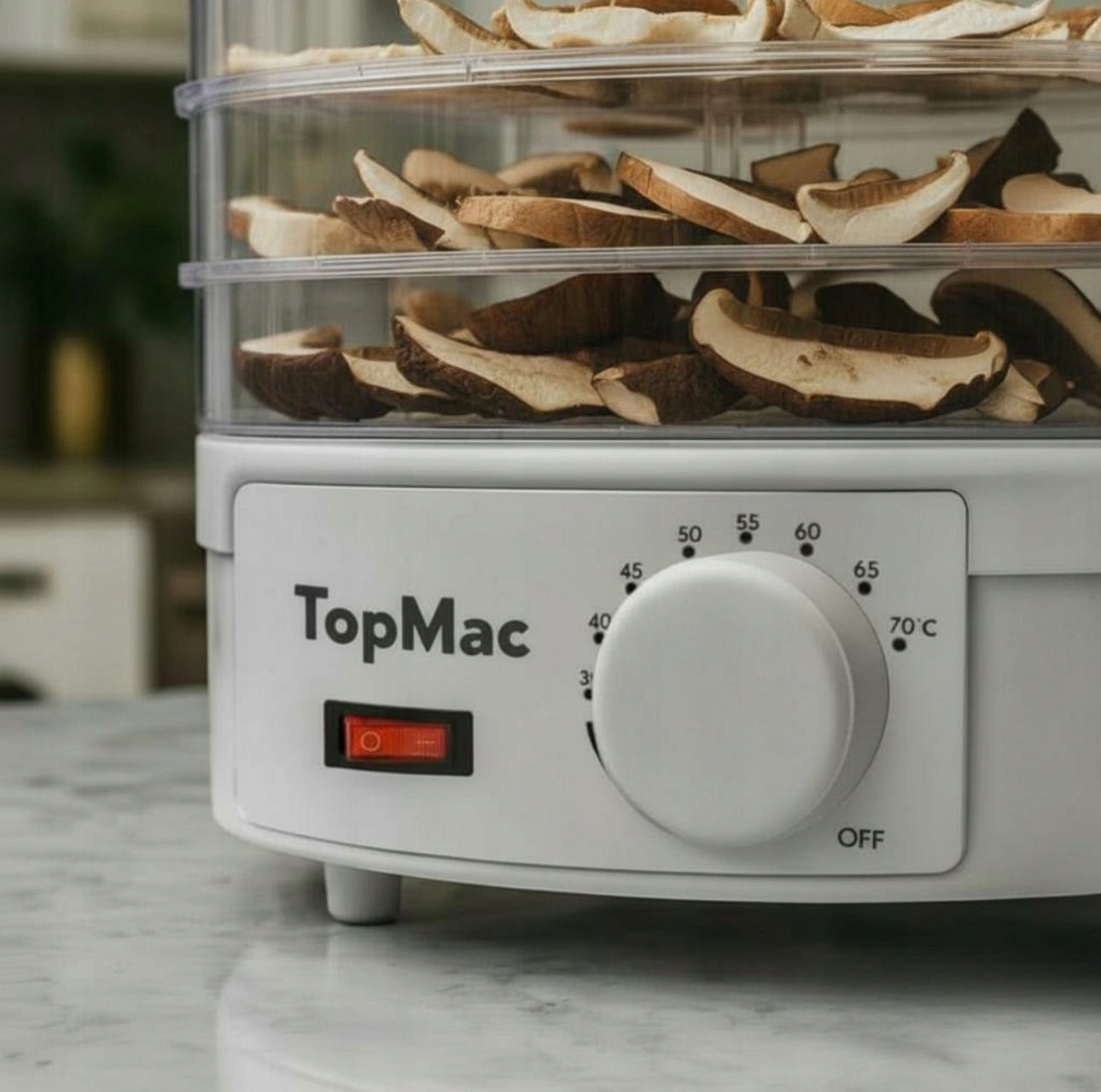 Nærbilde av temperaturhjul og sopp i nedre brett på matdehydrator i hvit plast
