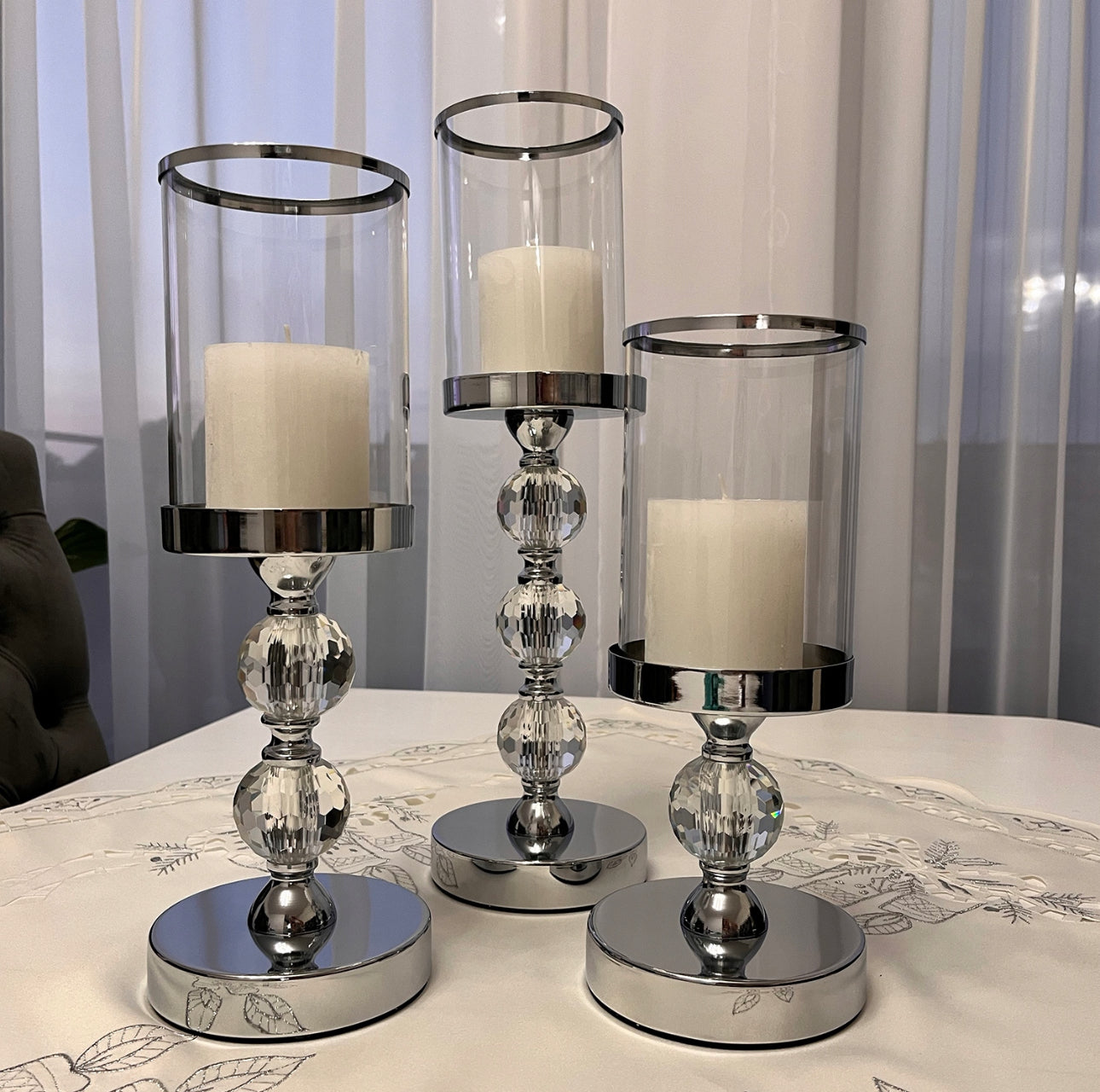 Sett med 3 lysestaker i sølvfinish med krystallkuler, laget av glass og metall, høyder på 28 cm, 34,3 cm og 40,9 cm, moderne design for elegant hjemmedekor.