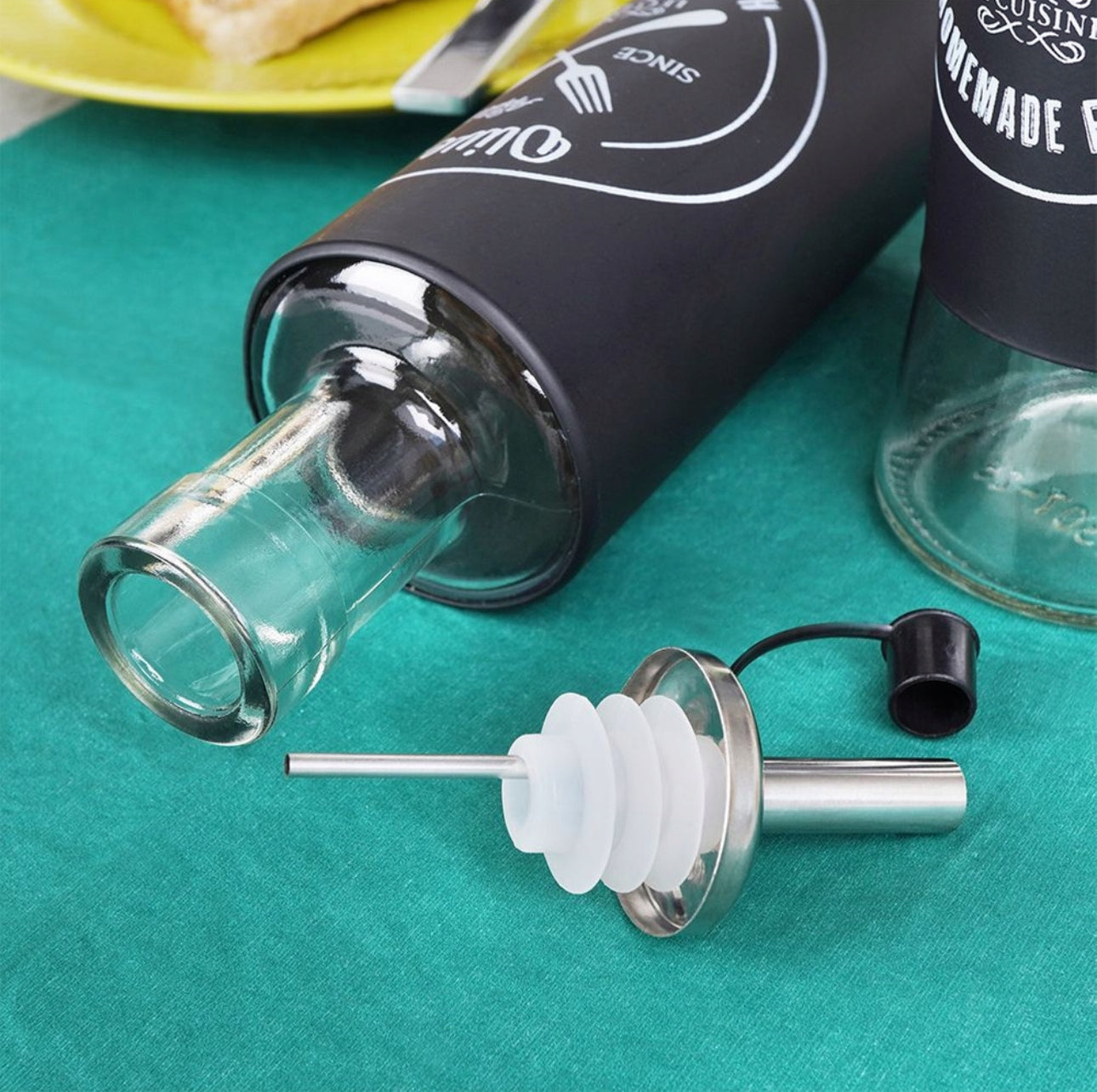 Åpen olivenoljeflaske med avtakbar tut og tydelig flaskehals i glass