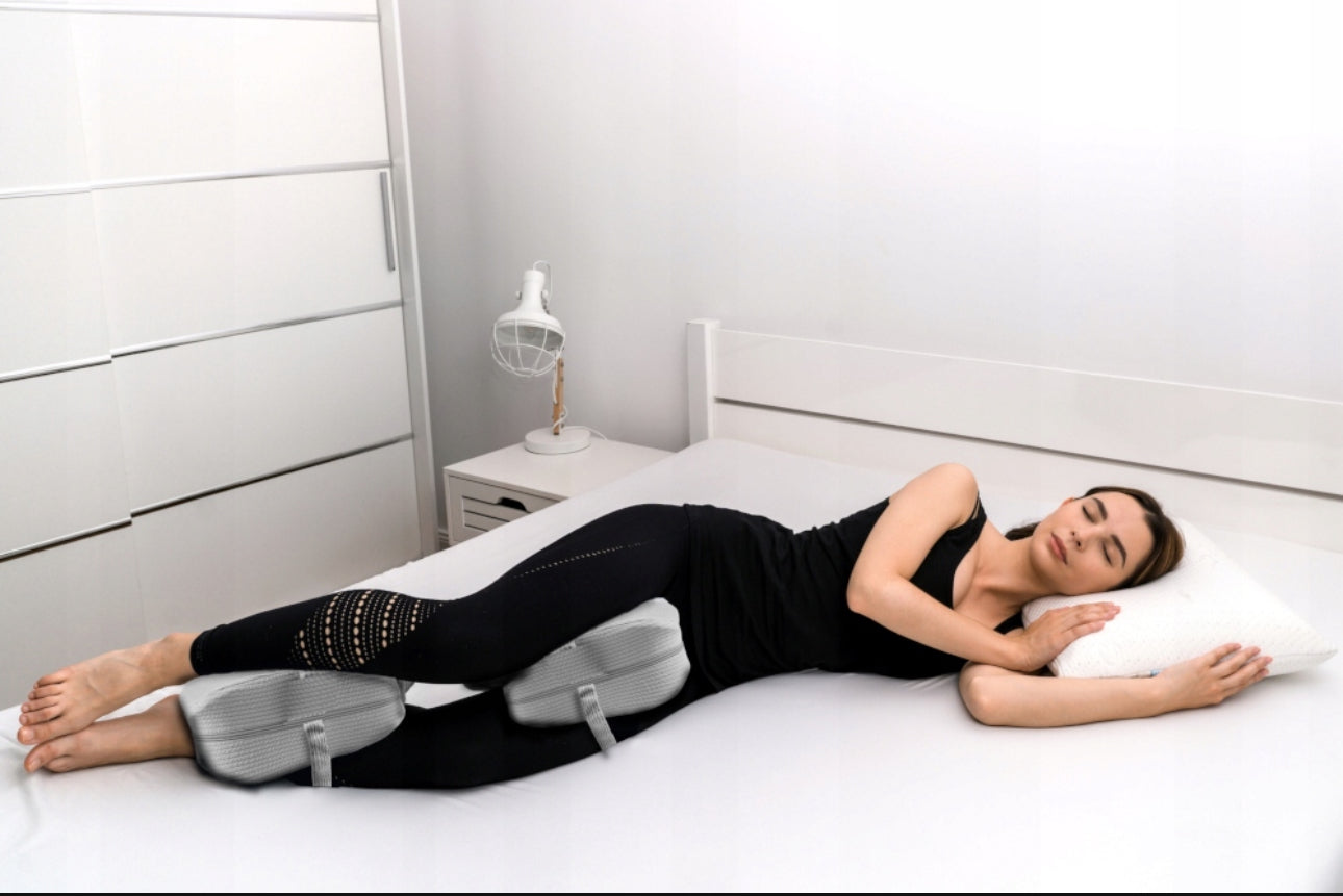 Grå ortopedisk knestøttepute i memory foam, størrelse 24x24x12 cm, med justerbar stropp og pustende trekk i slitesterkt polyester og elastan.