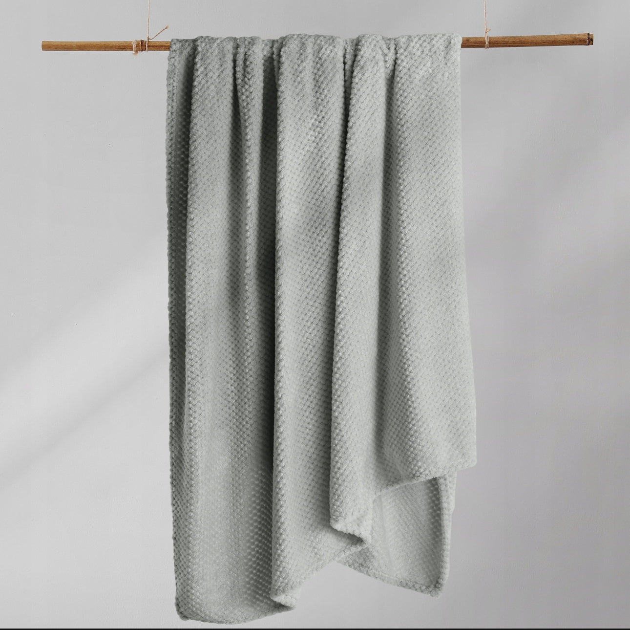 Grått pikért pledd, størrelse 220x240 cm, laget av myk og slitesterk 100 % polyester, perfekt som sengeteppe eller koseteppe.