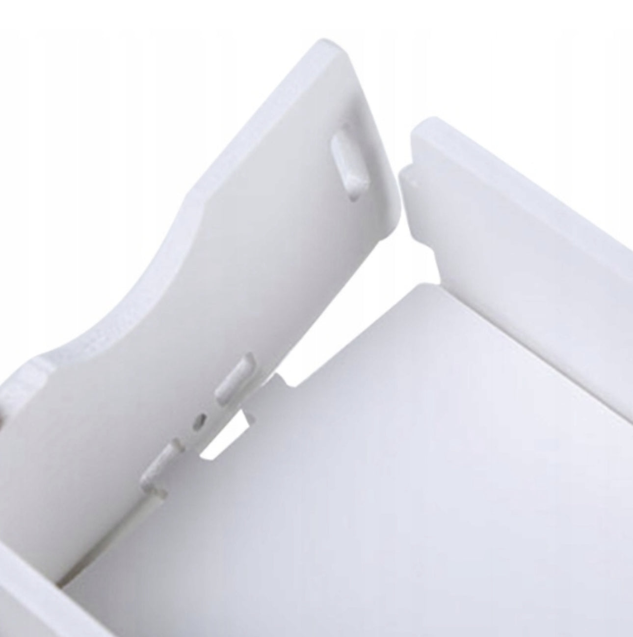 Nærbilde av hvit plastdel med tappfester for montering av kosmetikkorganiser