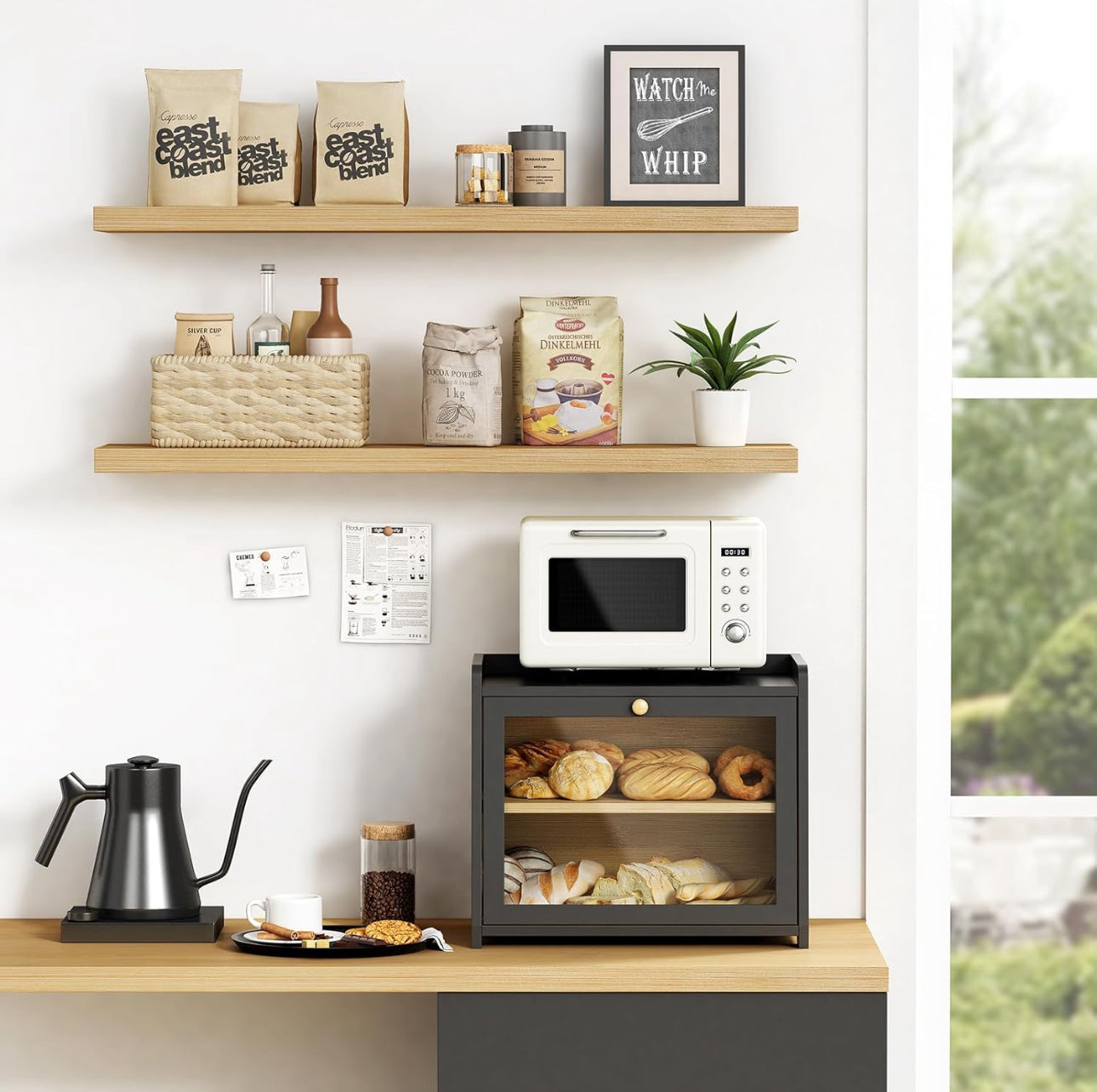 Moderne svart brødboks i bambus under hylle med kaffeutstyr og dekor