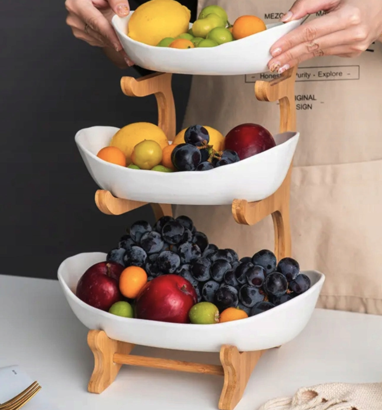 Hånd som holder øverste bolle på treetasjes fruktfat