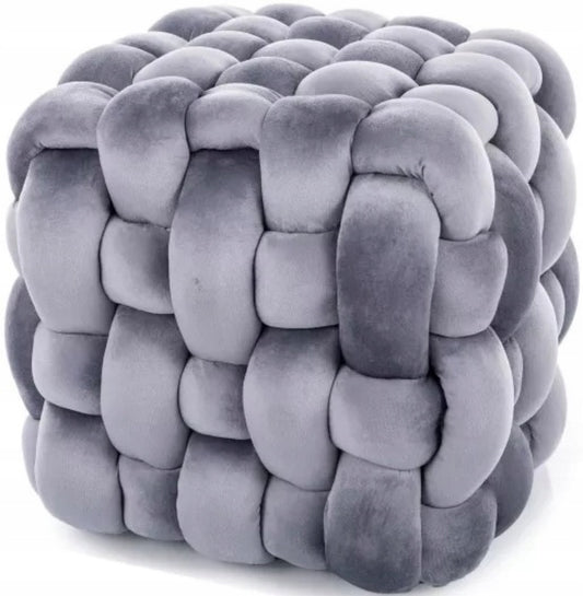 Grå puff med tykk, flettet overflate i velour, sett fra siden mot hvit bakgrunn