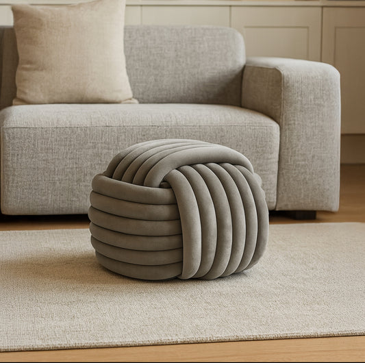 Grå puff i elegant stue med lys sofa og nøytral innredning i bakgrunnen
