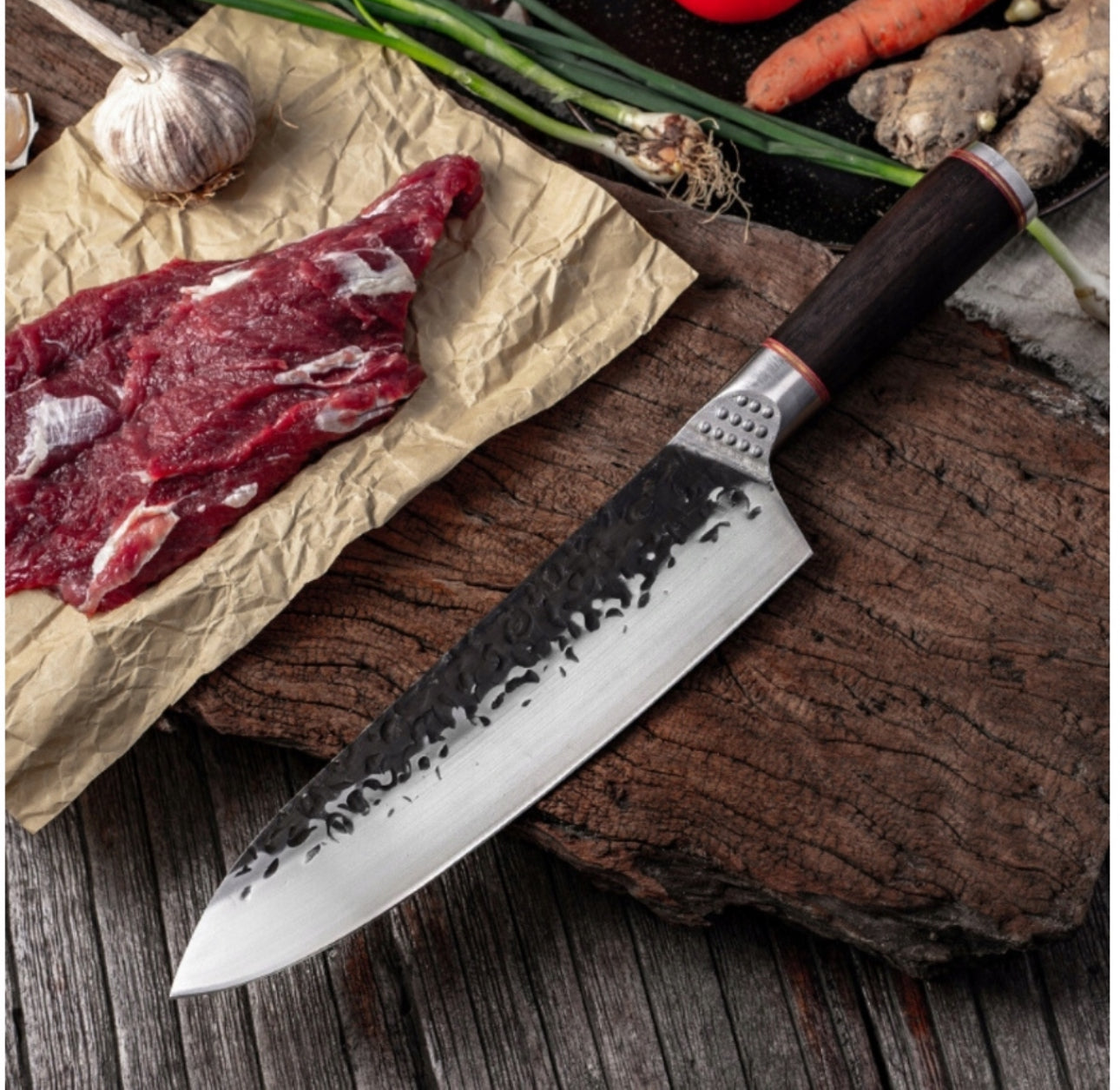 Kokkekniv med mønstret blad ved siden av rå biff og grønnsaker